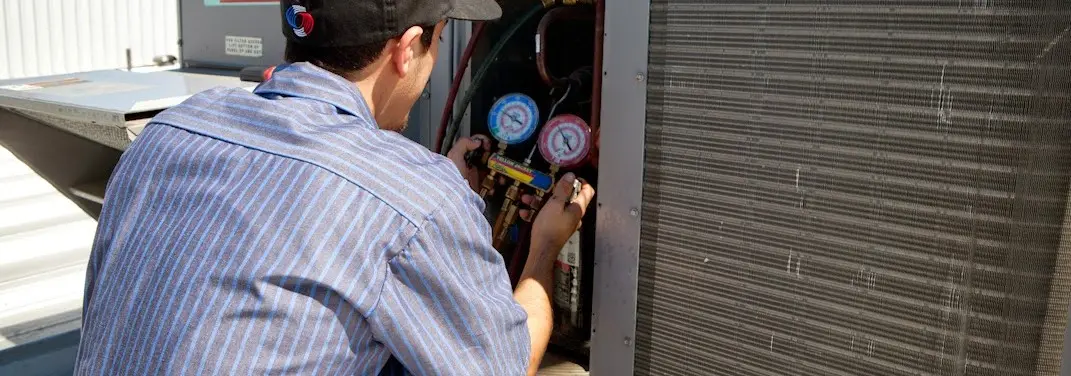 HVAC technician servicing a condenser unit in Silver Springs